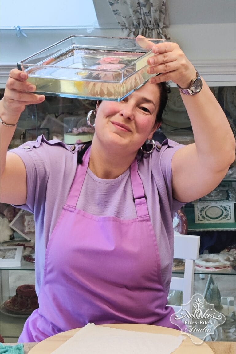 Résztvevő felemelve nézi a készülő zselévirágos tortáját.