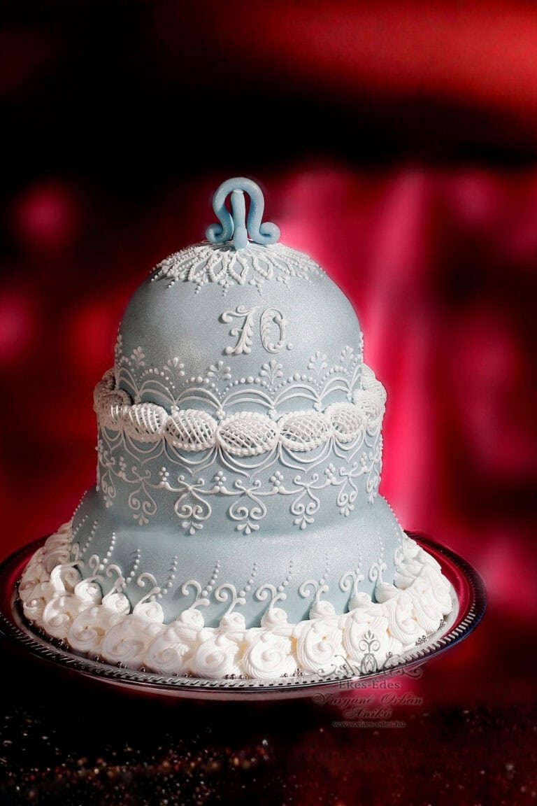 Fehér royal icinggal gazdagon díszített, elegáns ezüst színű, harang alakú torta.