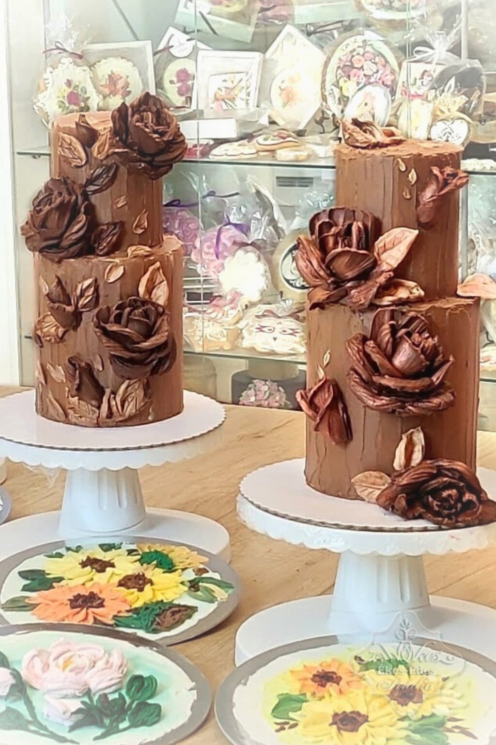 Résztvevők által készített emeletes csokoládé virágos emeletes torták, és gyakorló lapok részletesen kidolgozott csokoládévirág díszítéssel – Ékes-Édes Stúdió, tortadíszítő tanfolyam.