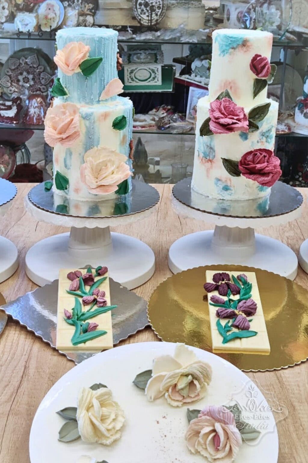 Tanfolyam végén az elkészült munkadarabok és színezett fehér csokoládéval díszített emeletes torták – Ékes-Édes Stúdió, tortadíszítő tanfolyam