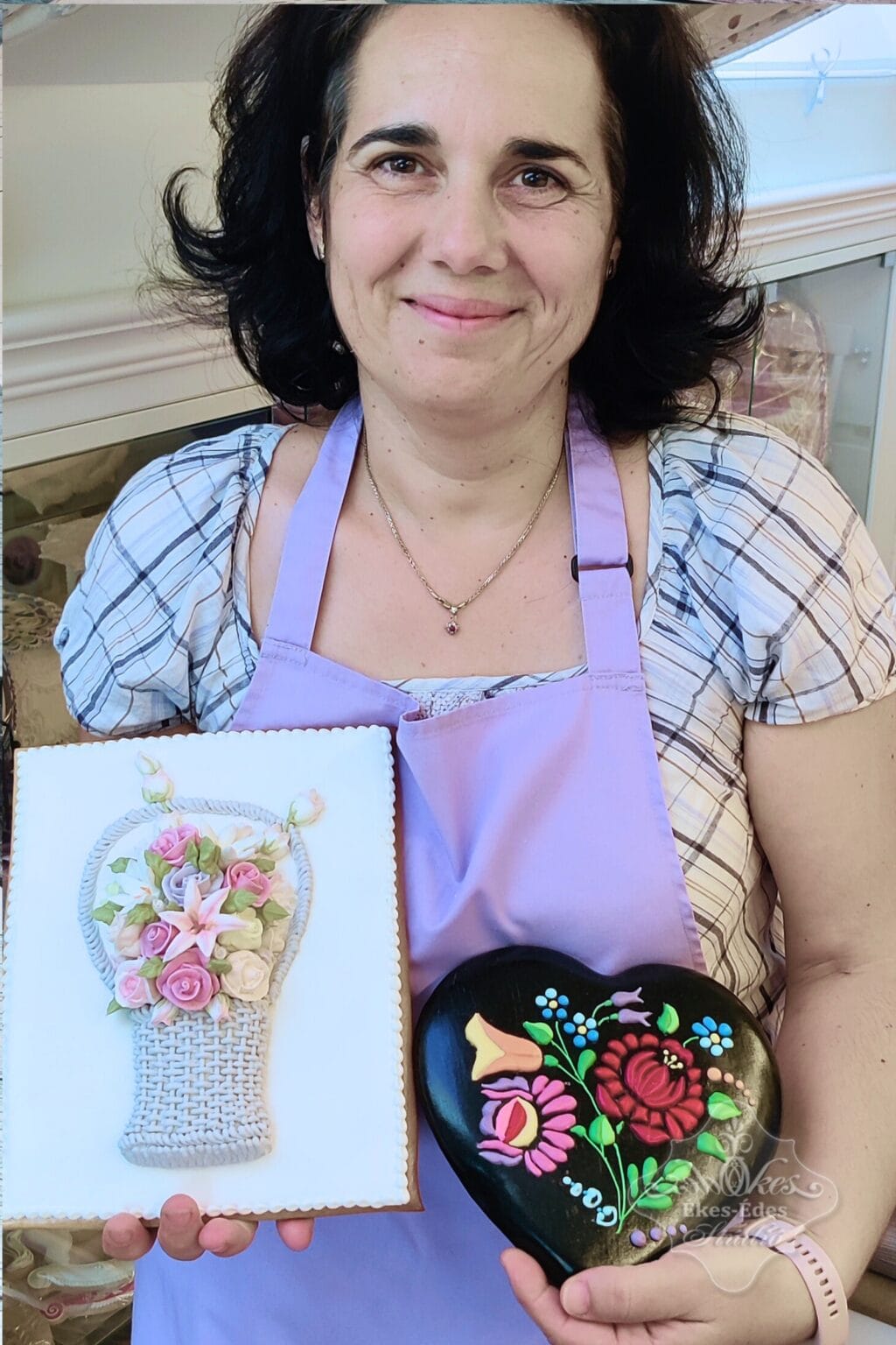 Tanfolyam végén mosolygó résztvevő mutatja az elkészült színes virágos cukormázas mézeskalácsait, amik többféle technikákkal készültek – Ékes-Édes Stúdió, mézeskalács díszítő tanfolyam