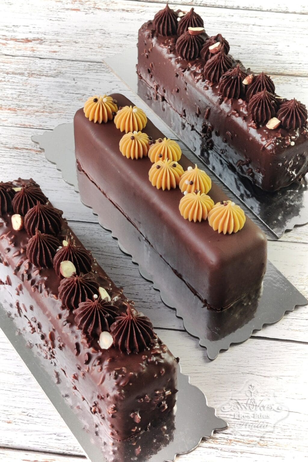 Három csokoládévak bevont, finom krémekkel töltött travel cake sütemény egy tálcán – Ékes-Édes Stúdió, Francia péksütemények tanfolyam