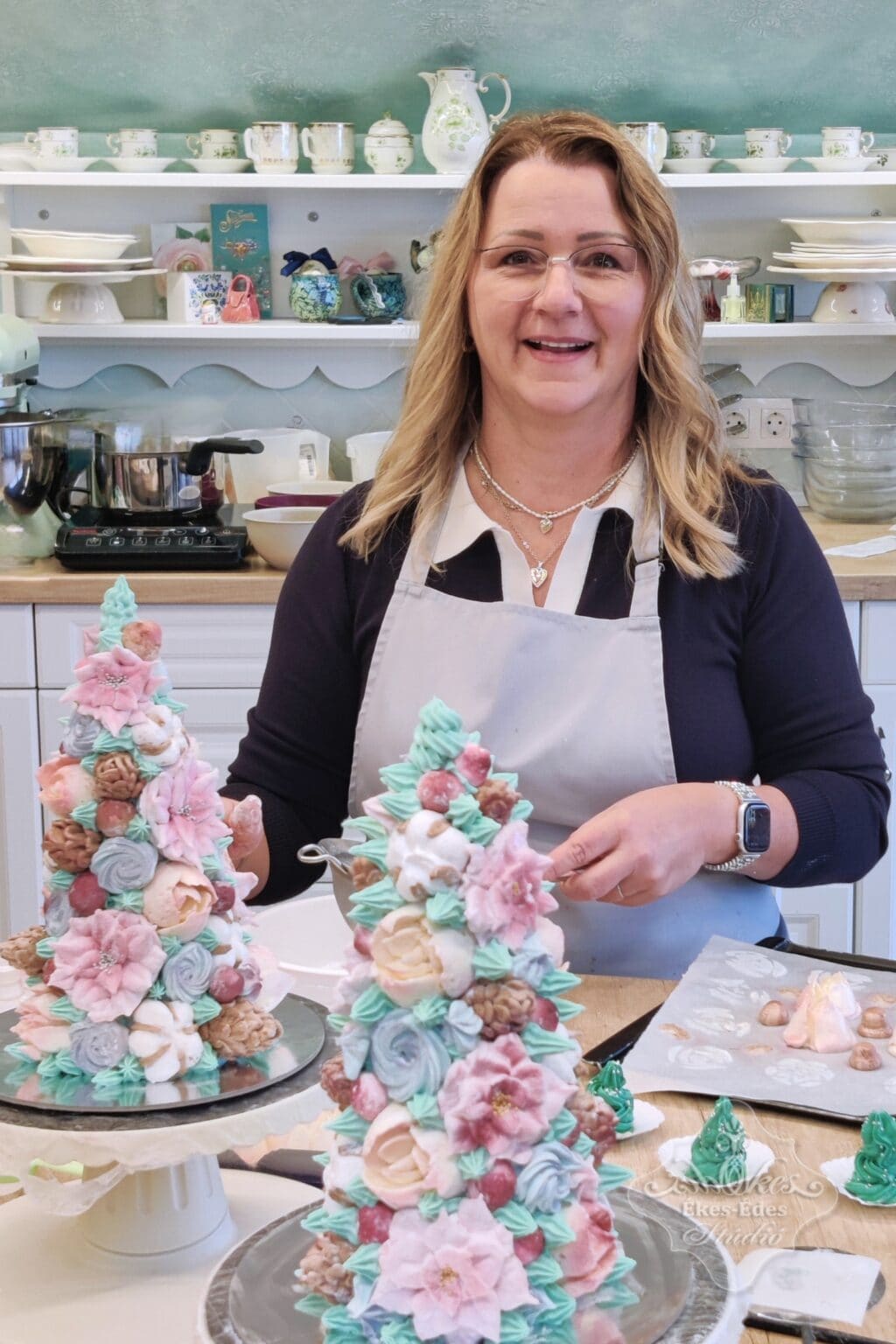 Ékes-Édes Stúdió karácsonyi pillecukor tanfolyamon teli asztal színes részletgazdag édességekkel, mögöttük egy résztvevő munka közben.