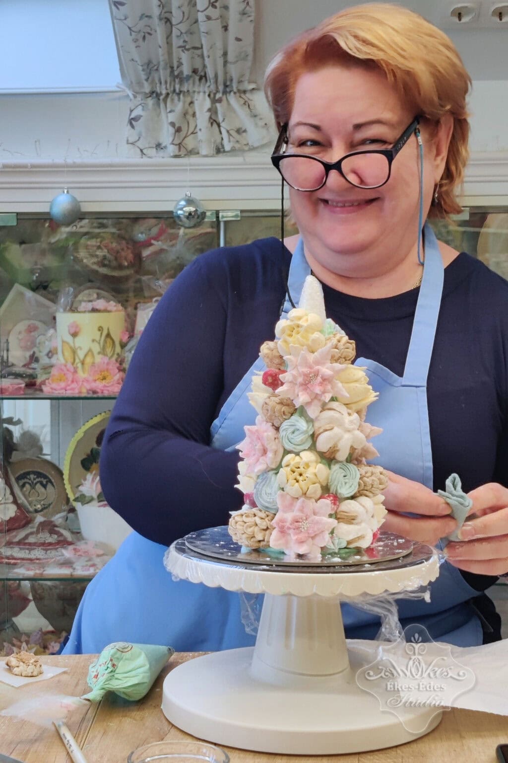 Karácsonyi pillecukor ajándék készítés közben vidám résztvevő mosolyog a kamerába, az Ékes-Édes Stúdió ünnepek előtti tanfolyamán