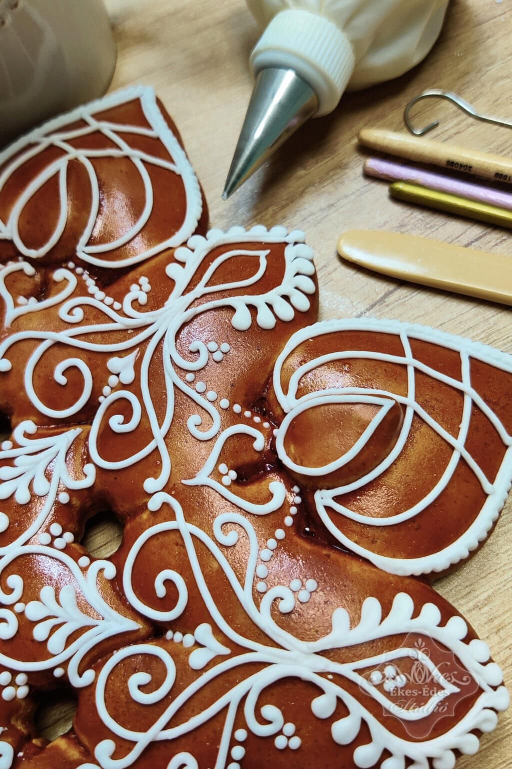 Mézeskalács díszítés fehér cukormázzal, részletes mintázattal egy közeli felvételen.