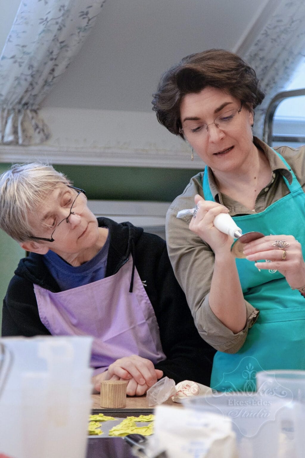 Pillecukor virágok készítése habzsákkal tanulóval és az oktatóval, aki részletesen bemutatva magyarázza a folyamatot.