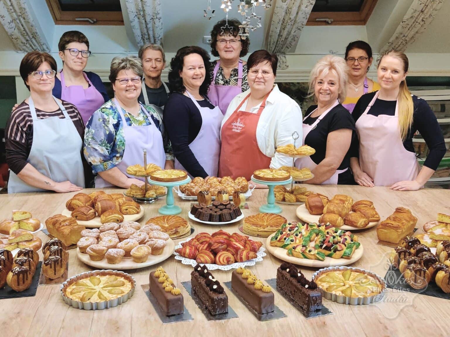 Ékes-Édes Stúdió francia péksütemények tanfolyam végén csoportkép a résztvevőkkel és asztalon a sokféle süeménnyel