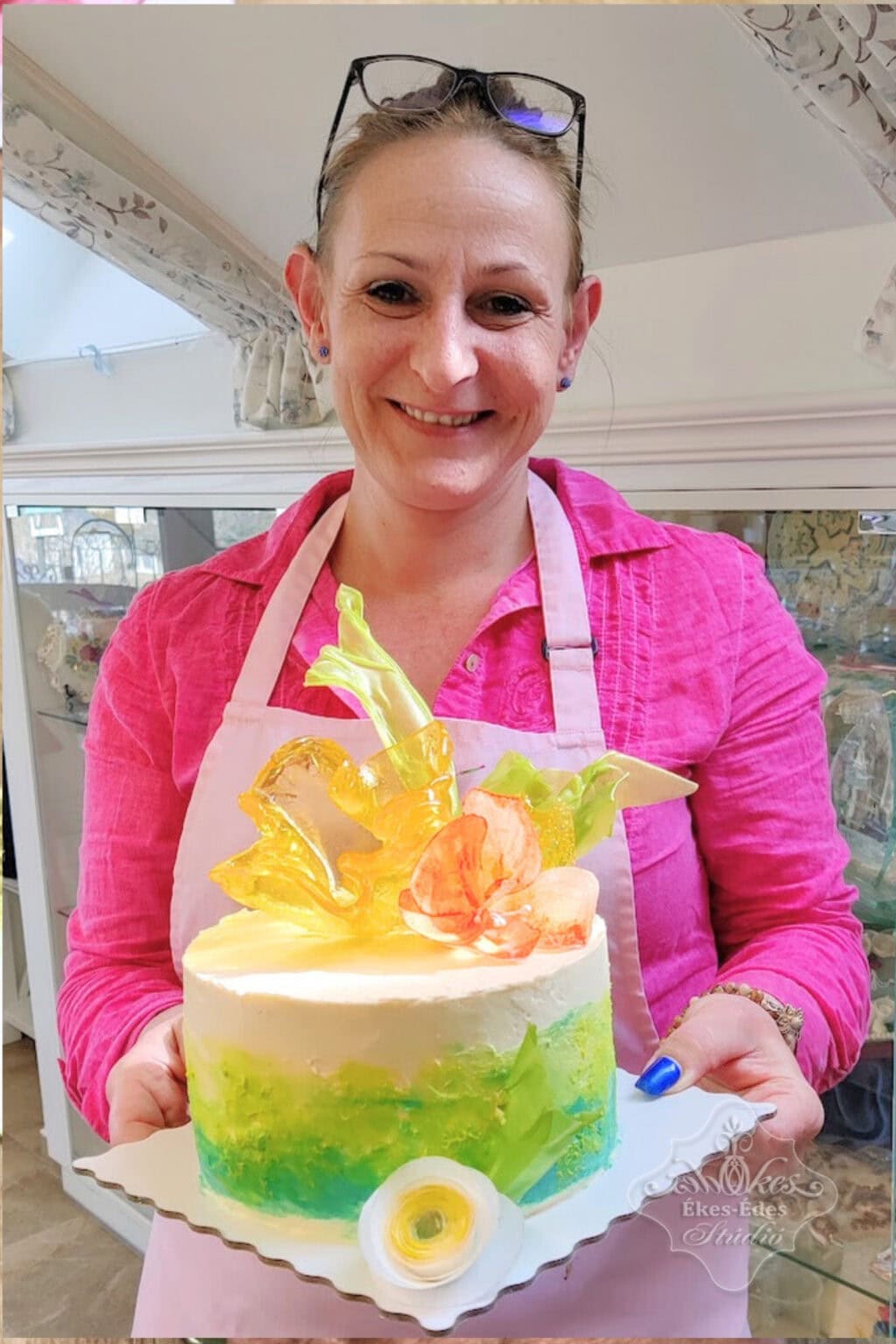 Résztevő vidáman mutatja a mentes tortáját, amin a díszek ostyapapír virágok és izomalt, valamint színes mentes vajrém burkolat– Ékes-Édes Stúdió, mentes cukrászat tanfolyam