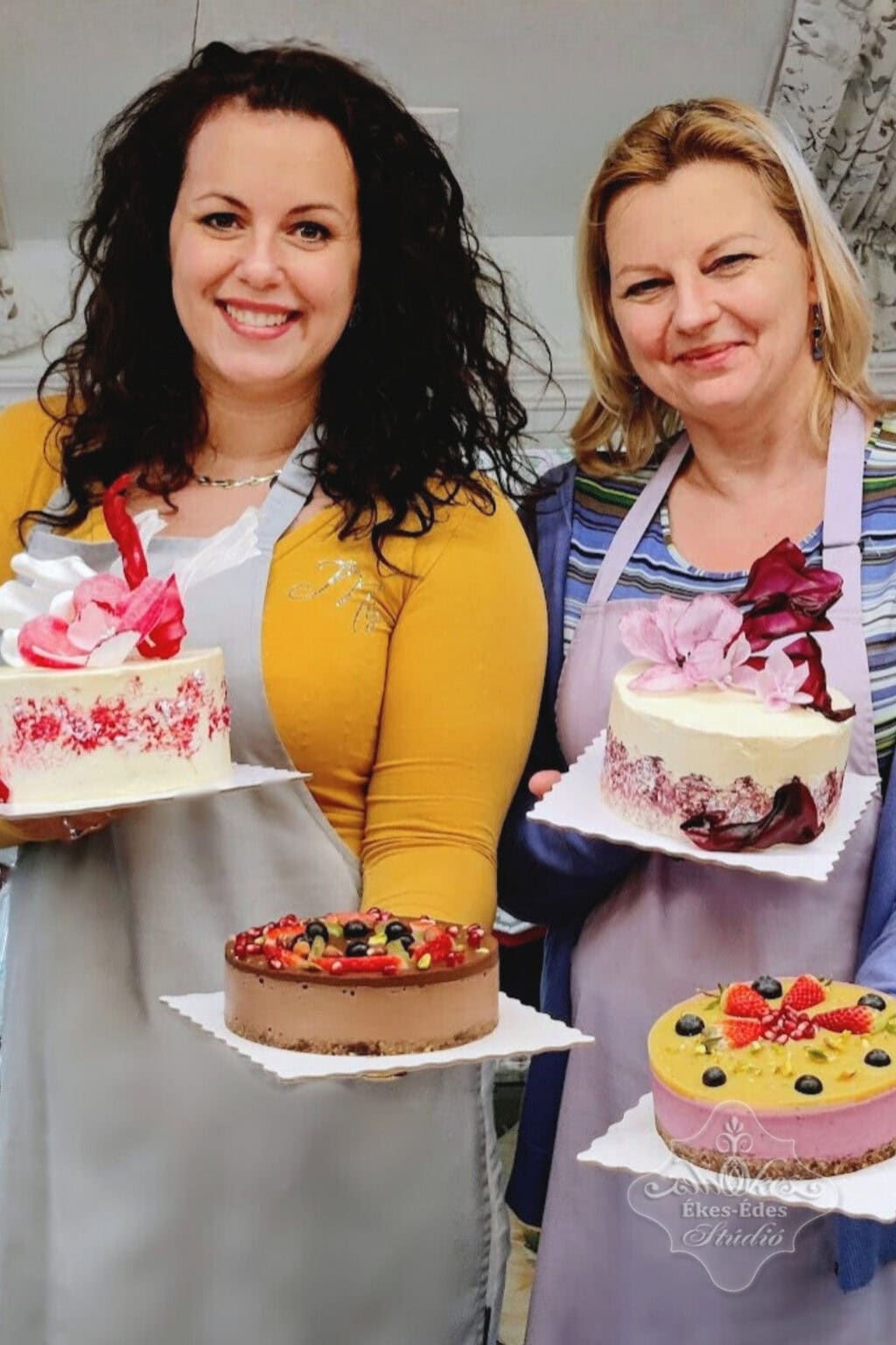 Két résztvevő a stúdióban, mindkettő boldogan tartja a tortáit, melyek között különleges mentes desszertek is találhatók – Ékes-Édes Stúdió, mentes cukrászat tanfolyam