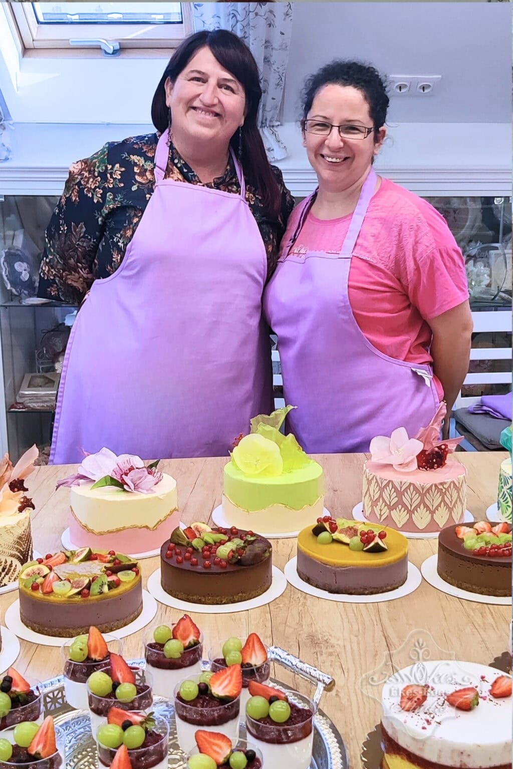 Kézművesmentes torták és sütemények az Ékes-Édes Stúdióban, két boldog résztvevő a háttérben – Ékes-Édes Stúdió, mentes cukrászat tanfolyam végén