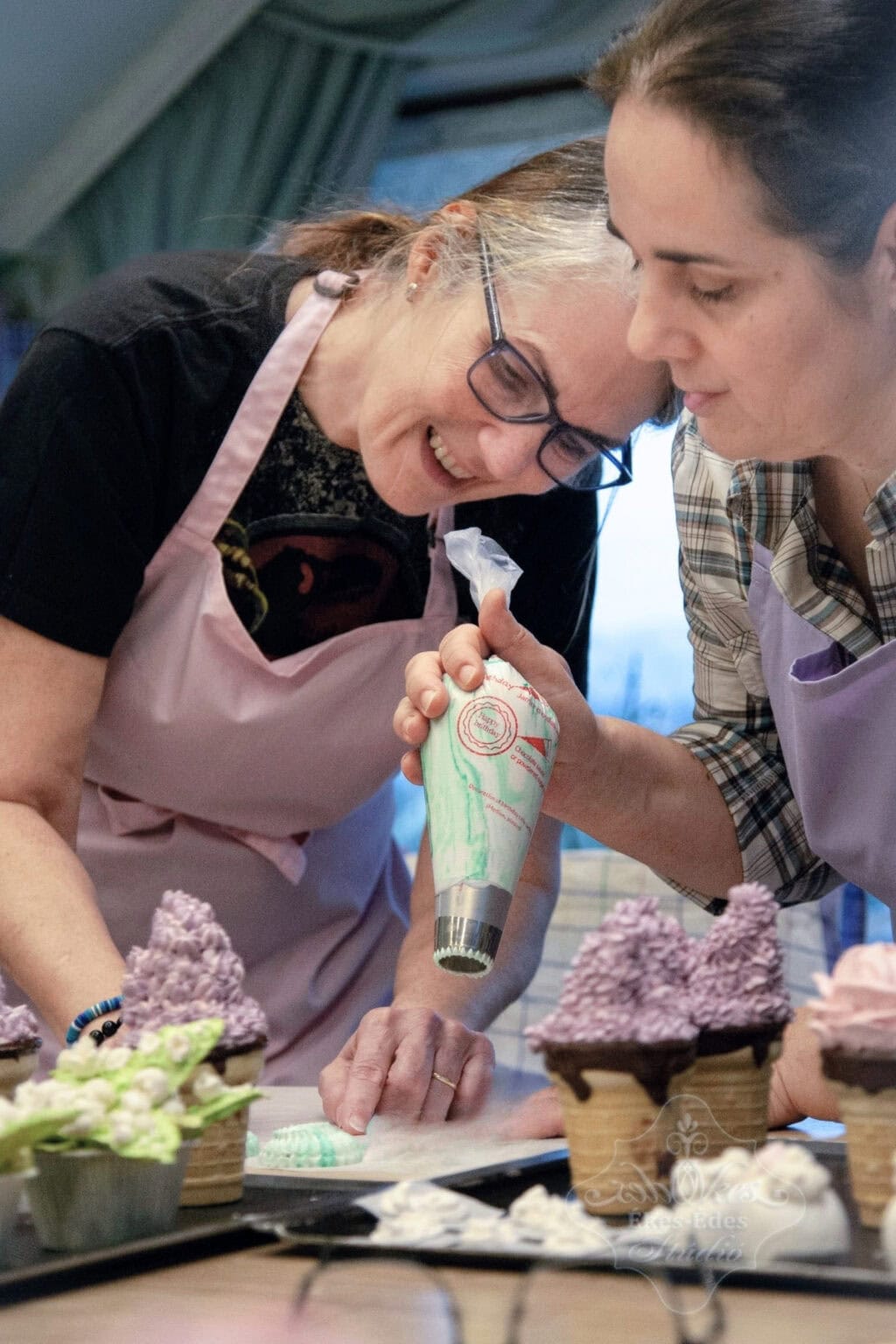 Pillecukor karika készítéshabzsákkal és szultáncsővel, ahol a résztvevők gyakorolják a tanultakat – előtérben az sokféle elkészült pillecukor virágokkal.