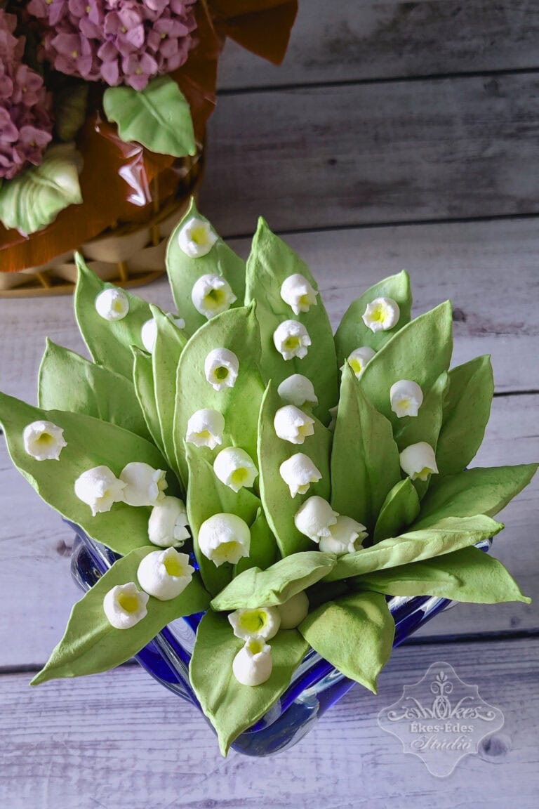 Pillecukorból készült élethű gyöngyvirág csokor látható a képen.