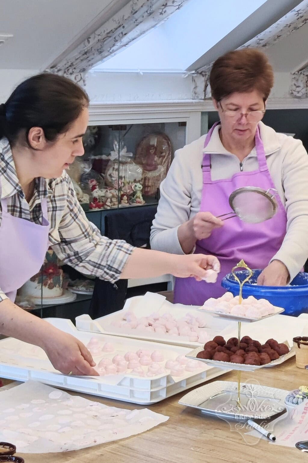 Pillecukor tanfolyamon az elkészült termékeket a résztvevők porcukorba forgatják