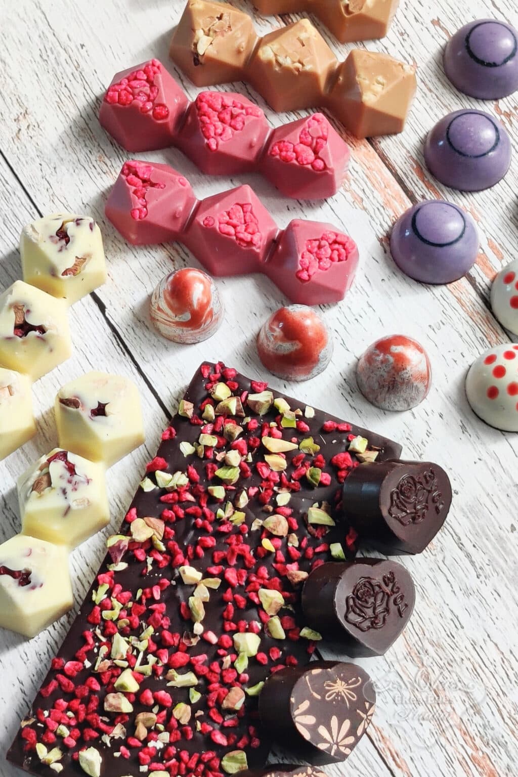 Vegyes színekben és formákban többféle bonbon és egy kreatív csokoládé tábla