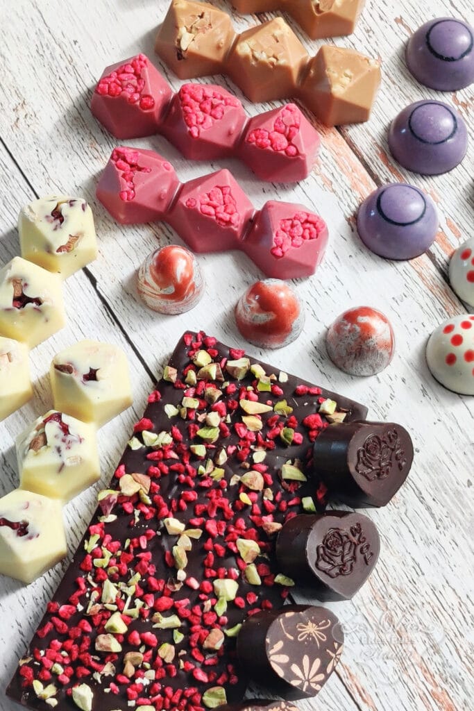Vegyes színekben és formákban többféle bonbon és egy kreatív csokoládé tábla