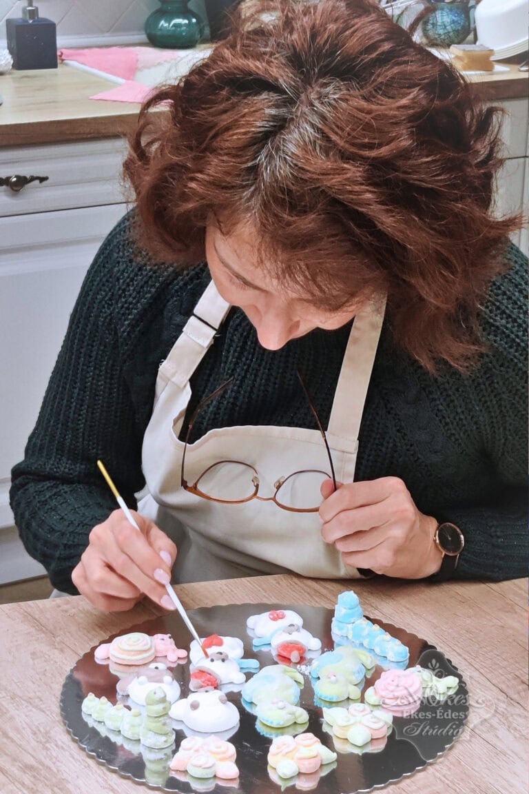 Ékes-Édes Stúdió műhelyében tanfolyamon egy résztvevő közelről fotózva, az elkészített fotókra fest, szemeket, arcocskát, szájat.