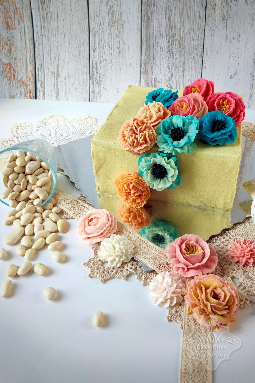Ékes-Édes stúdió színes virágos babkrém torta dekoráció, finom és elegáns esküvői vagy ünnepi sütemény.