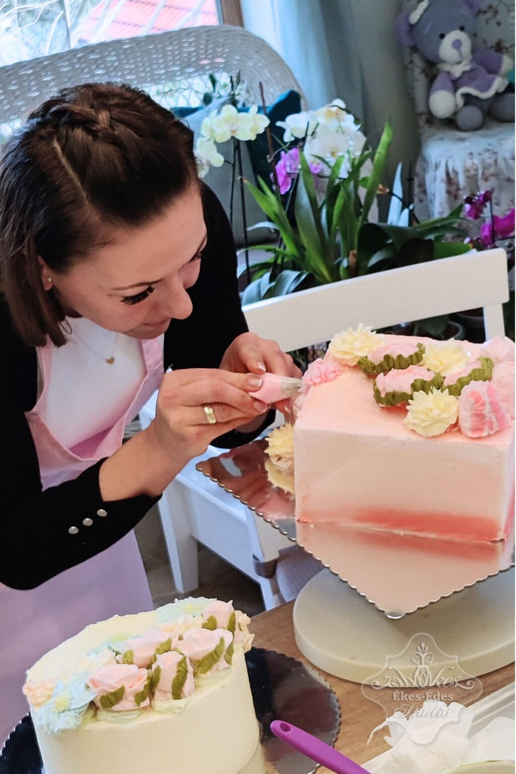Vajkrém virágos tanfolyamon torta díszítése közben résztvevő