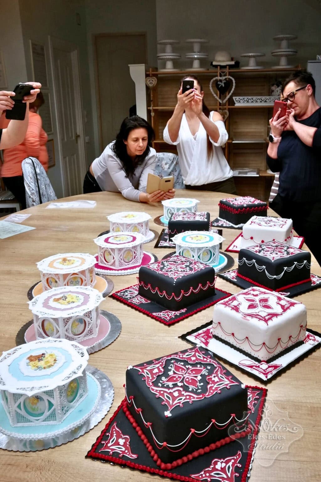 Royal icing tortadíszítés tanfoylam végén résztvevők a tortáikat fotózzák.